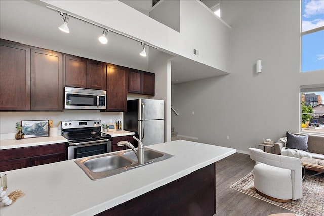 600 Douglas St NW Unit 600C, Grand Rapids, MI 49504 - kitchen with stainless steel appliances, a sink, dark brown cabinets, wood finished floors, and light countertops