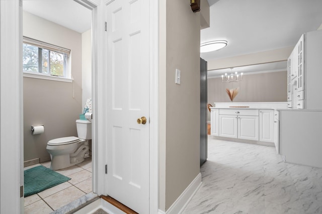 hall with a chandelier and baseboards