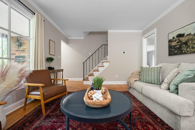 living area featuring wood finished floors, ornamental molding, stairway, and baseboards