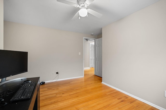 living area with baseboards, light wood-style flooring, ceiling fan, and a desk