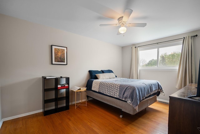 bedroom with wood finished floors, baseboards, and a ceiling fan