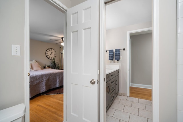 bathroom with ceiling fan, tile patterned flooring, toilet, vanity, and connected bathroom