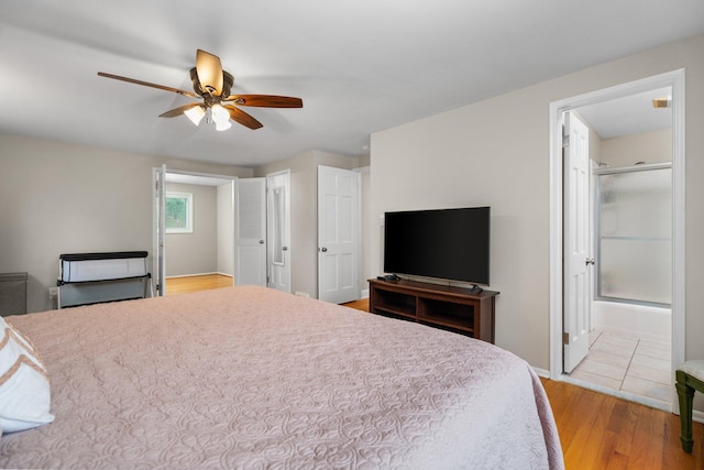 bedroom with light wood-type flooring, baseboards, a ceiling fan, and ensuite bathroom