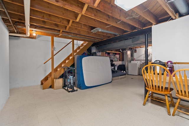 unfinished below grade area with washer / dryer, tile patterned floors, and stairway