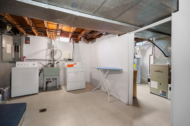 unfinished below grade area with water heater, washing machine and clothes dryer, electric panel, and tile patterned floors