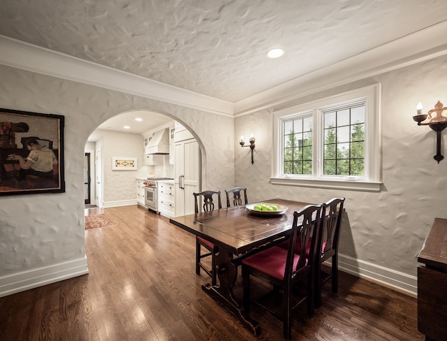 404 Linden Rd, Birmingham, MI 48009 - dining room with arched walkways, dark wood-style flooring, baseboards, a textured ceiling, and crown molding