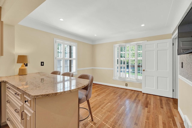 950 W Lincoln St, Birmingham, MI 48009 - kitchen with a breakfast bar, healthy amount of natural light, light wood-style floors, light stone counters, and recessed lighting