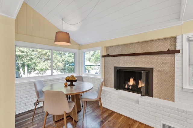 950 W Lincoln St, Birmingham, MI 48009 - dining area featuring vaulted ceiling, hardwood / wood-style floors, plenty of natural light, and a brick fireplace