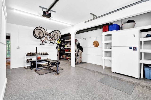 950 W Lincoln St, Birmingham, MI 48009 - garage featuring freestanding refrigerator, a garage door opener, and baseboards