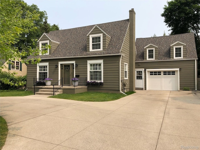 950 W Lincoln St, Birmingham, MI 48009 - new england style home with a shingled roof, concrete driveway, an attached garage, and a chimney