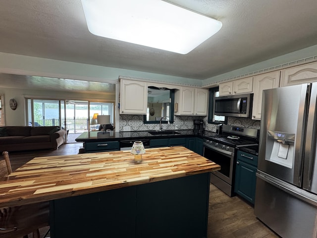 11619 Scott Park Rd, Delton, MI 49046 - kitchen featuring appliances with stainless steel finishes, a sink, wooden counters, and white cabinets