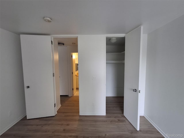 8200 E Jefferson Ave Unit 59/602, Detroit, MI 48214 - unfurnished bedroom with wood finished floors, a closet, baseboards, and a walk in closet