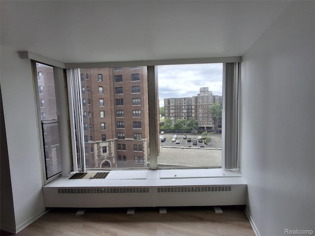 8200 E Jefferson Ave Unit 59/602, Detroit, MI 48214 - empty room featuring wood finished floors, a view of city, and baseboards