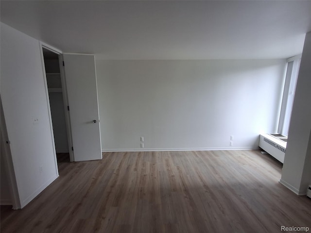 8200 E Jefferson Ave Unit 59/602, Detroit, MI 48214 - unfurnished bedroom with wood finished floors, radiator, and baseboards