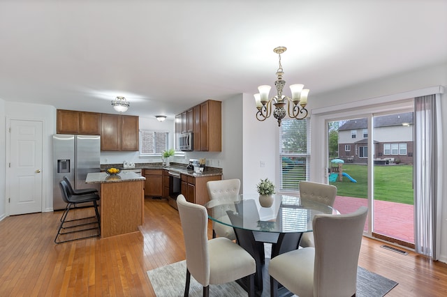 14190 Elmhurst Dr, Sterling Heights, MI 48313 - dining area with a chandelier and light wood-style floors