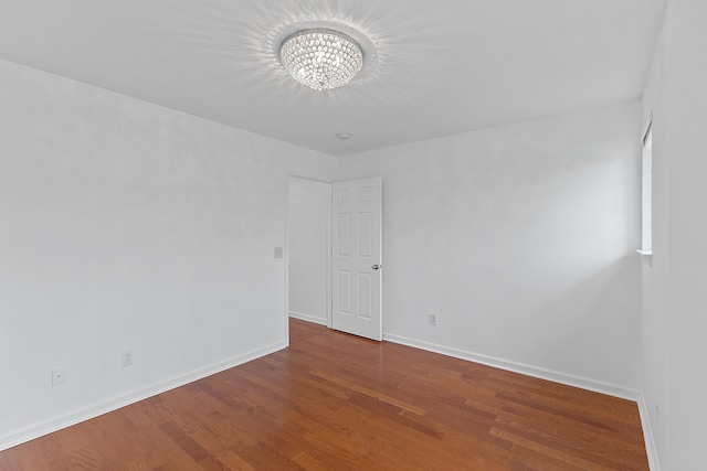 14190 Elmhurst Dr, Sterling Heights, MI 48313 - spare room with a chandelier, wood finished floors, and baseboards