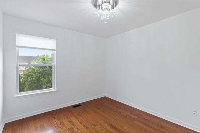 14190 Elmhurst Dr, Sterling Heights, MI 48313 - unfurnished room featuring wood finished floors, baseboards, and a chandelier