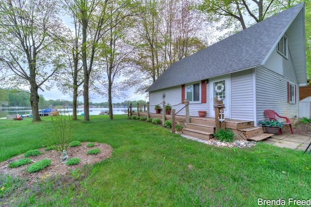 2551 Mayo Dr, Fremont, MI 49412 - view of front of home featuring roof with shingles, a front lawn, and a water view