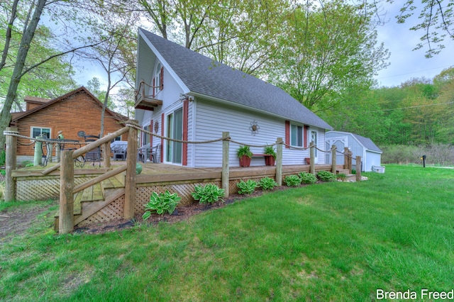 2551 Mayo Dr, Fremont, MI 49412 - view of property exterior featuring a wooden deck, roof with shingles, a yard, a shed, and an outdoor structure