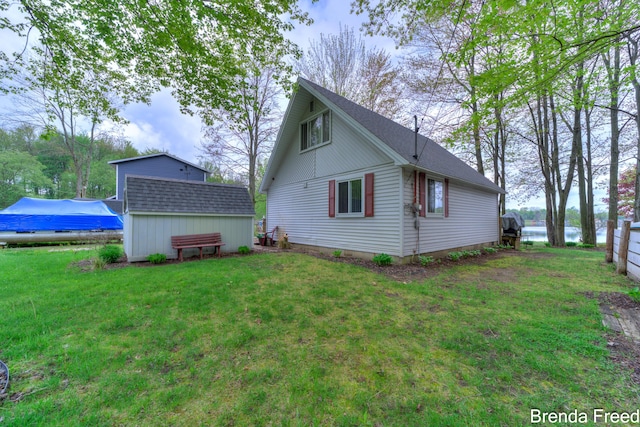2551 Mayo Dr, Fremont, MI 49412 - view of home's exterior featuring a lawn, an outbuilding, and a water view