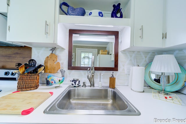 2551 Mayo Dr, Fremont, MI 49412 - kitchen featuring a sink, light countertops, tasteful backsplash, and white cabinetry