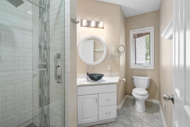 full bathroom featuring a stall shower, tile patterned flooring, toilet, vanity, and baseboards
