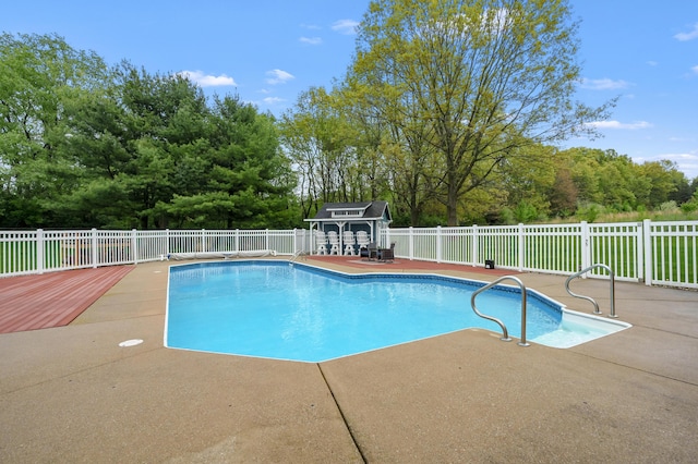view of swimming pool featuring a patio and fence