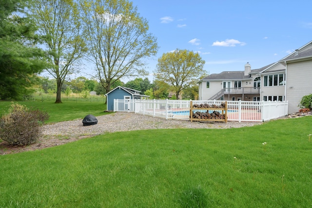 view of yard featuring an outbuilding, stairs, a wooden deck, a fire pit, and a storage unit