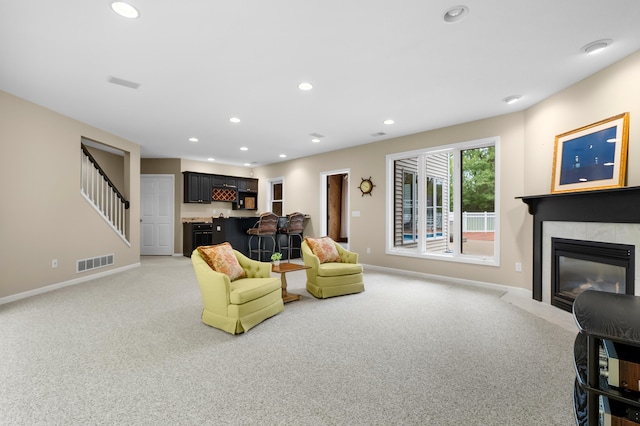 living room with baseboards, light colored carpet, a fireplace with flush hearth, and recessed lighting