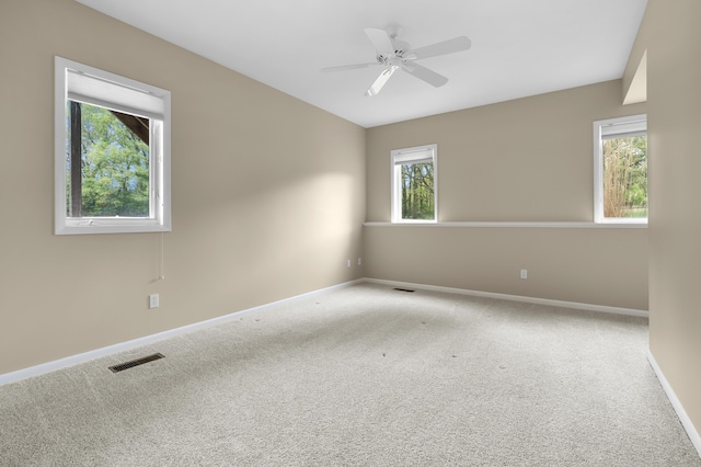empty room featuring carpet flooring, baseboards, and a ceiling fan