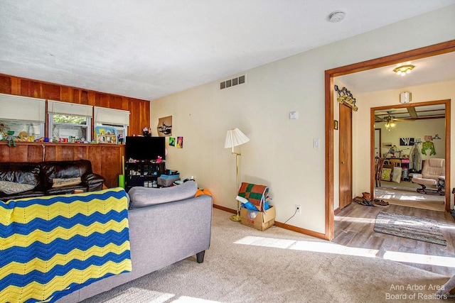 carpeted living room featuring ceiling fan and baseboards