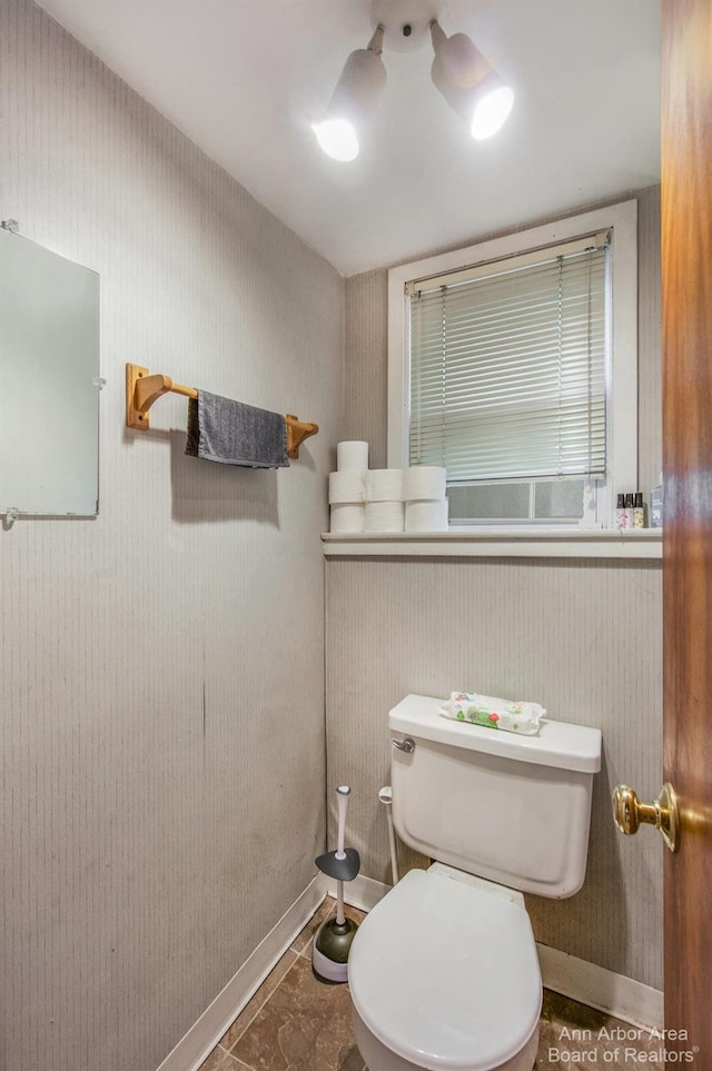 half bathroom with toilet and baseboards