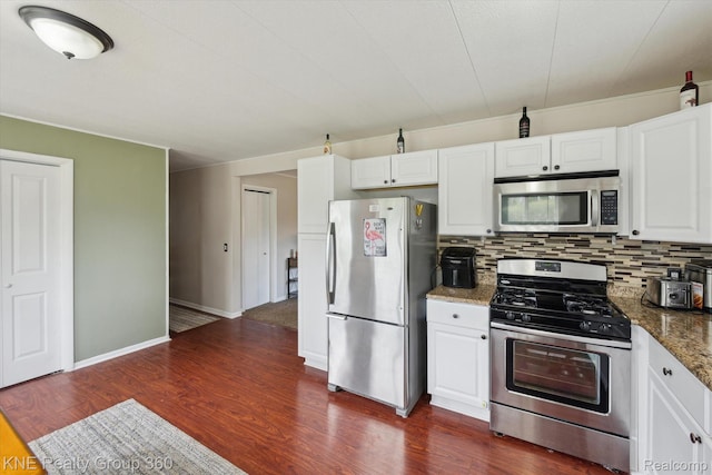 5170 Warmbriar Dr, White Lake, MI 48383 - kitchen with appliances with stainless steel finishes, white cabinetry, backsplash, dark wood-type flooring, and dark stone countertops