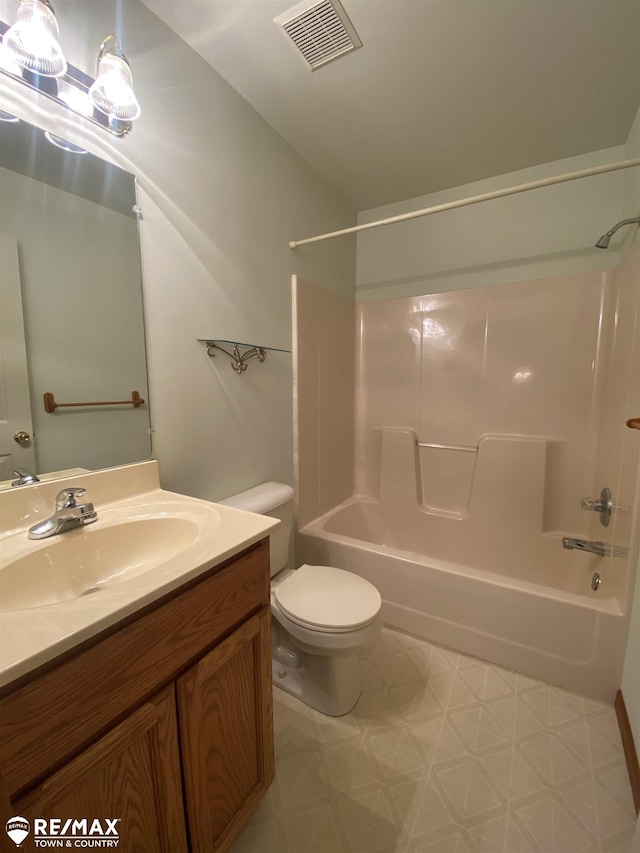 bathroom featuring tile patterned floors, shower / bath combination, toilet, and vanity