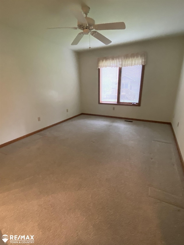 empty room featuring light carpet, baseboards, and a ceiling fan