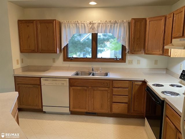 kitchen with electric range oven, a sink, white dishwasher, under cabinet range hood, and brown cabinets