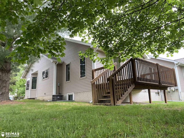 back of property with stairway, a deck, cooling unit, and a yard