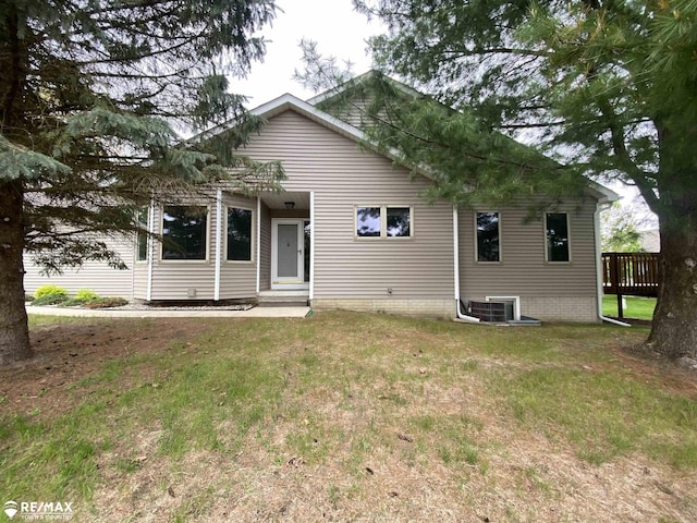 back of property with a yard, entry steps, and central AC unit