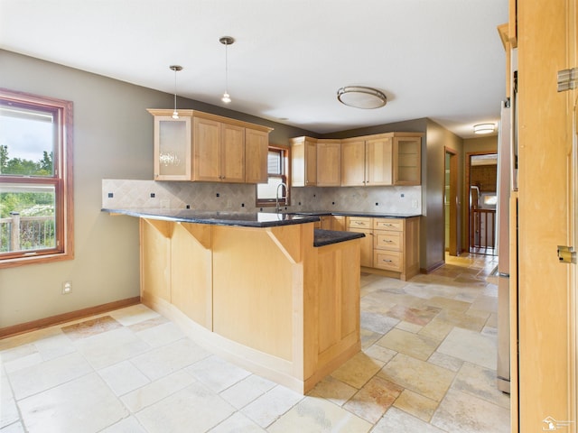 5015 Piehl Rd, Ottawa Lake, MI 49267 - kitchen featuring decorative backsplash, a peninsula, glass insert cabinets, a breakfast bar area, and hanging light fixtures