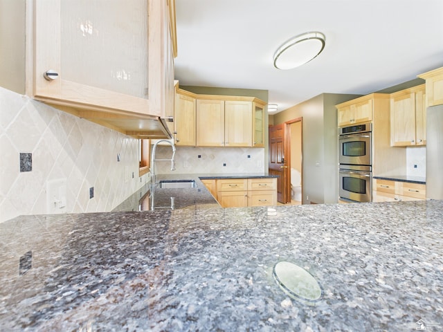 5015 Piehl Rd, Ottawa Lake, MI 49267 - kitchen with double oven, light brown cabinetry, dark stone counters, and decorative backsplash