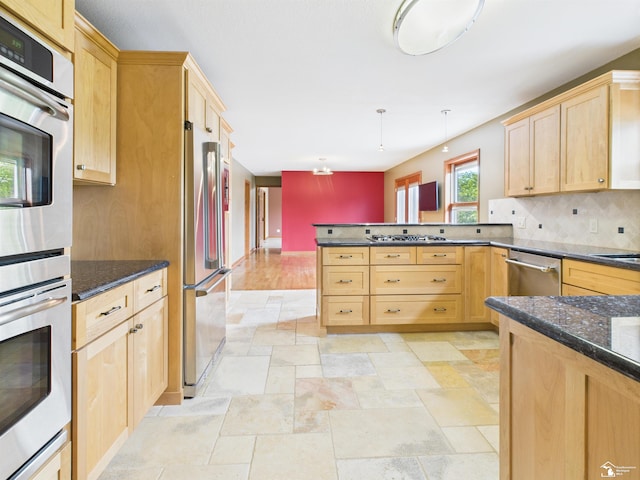5015 Piehl Rd, Ottawa Lake, MI 49267 - kitchen with appliances with stainless steel finishes, light brown cabinetry, a peninsula, stone tile flooring, and backsplash