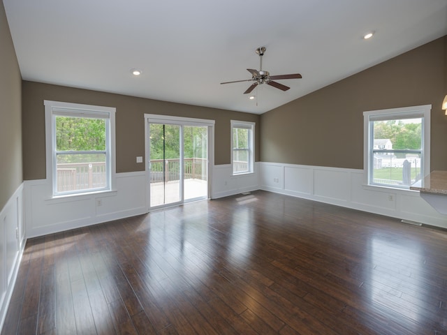 spare room with a ceiling fan, wainscoting, vaulted ceiling, dark wood-style floors, and a decorative wall