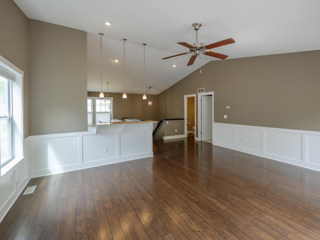 unfurnished living room featuring ceiling fan, a decorative wall, a wainscoted wall, dark wood-type flooring, and high vaulted ceiling