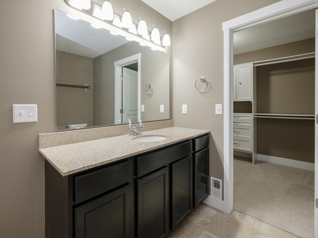 bathroom featuring vanity, tile patterned flooring, and baseboards