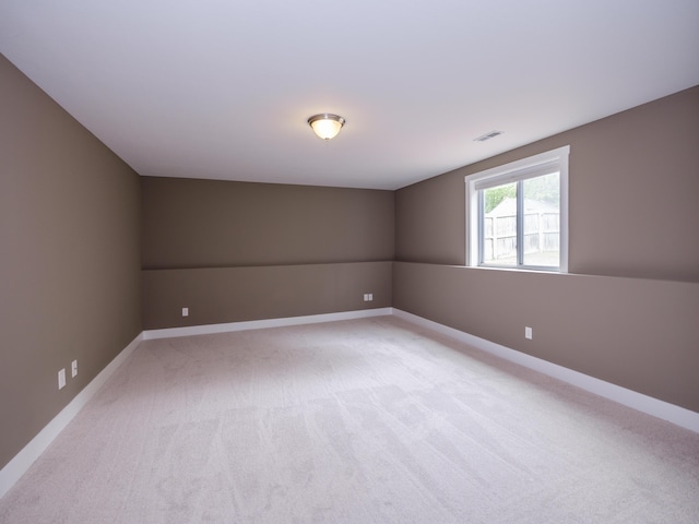 empty room featuring light colored carpet and baseboards