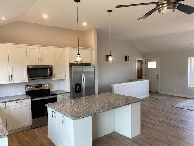 9745 W Michigan Ave, Grass Lake, MI 49240 - kitchen with stainless steel appliances, lofted ceiling, a kitchen island, a ceiling fan, and tasteful backsplash