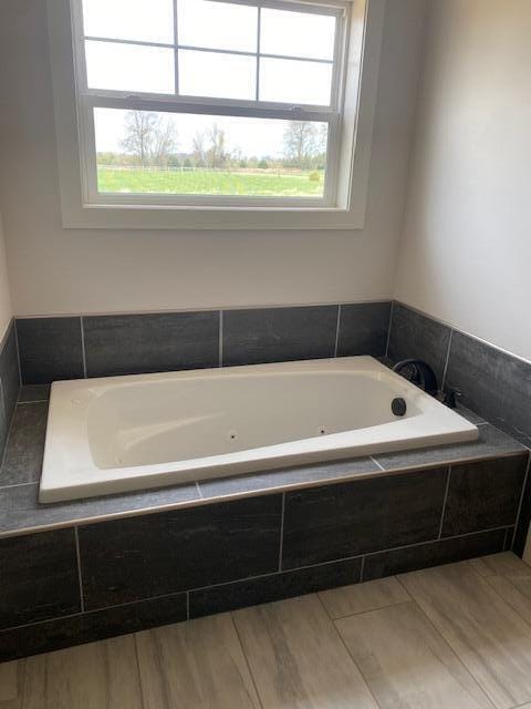 9745 W Michigan Ave, Grass Lake, MI 49240 - full bathroom featuring a jetted tub and wood finished floors