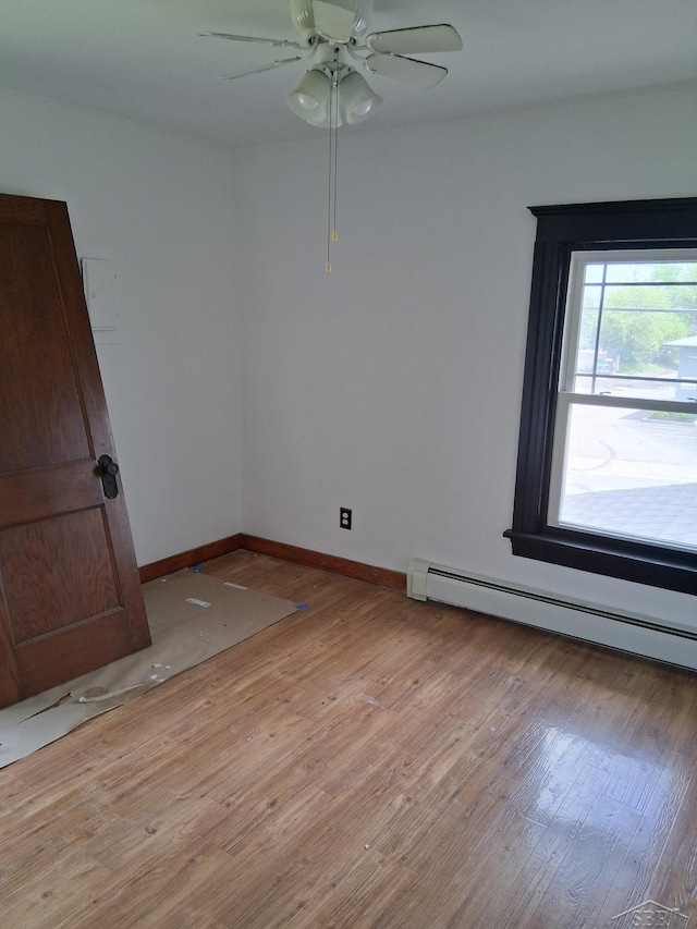 908 Lansing Ave, Jackson, MI 49202 - spare room with light wood-style flooring, ceiling fan, baseboard heating, and baseboards