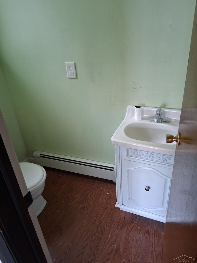 908 Lansing Ave, Jackson, MI 49202 - bathroom featuring a baseboard radiator, vanity, toilet, and wood finished floors
