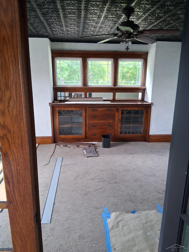 908 Lansing Ave, Jackson, MI 49202 - unfurnished living room with plenty of natural light, carpet flooring, baseboards, a ceiling fan, and an ornate ceiling